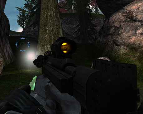 A black SMG with a gold-plated scope lens, flashlight on in broad daylight, and ammunition packs haphazardly attached to its stock and the Master Chief's arms.